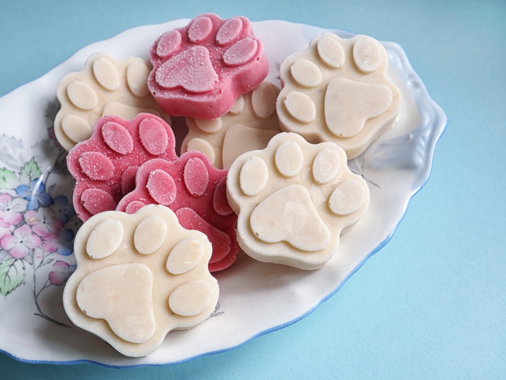 Close-up photo of homemade dog treats, a popular Valentine's Day gift for dogs, in a floral dish on a blue background.