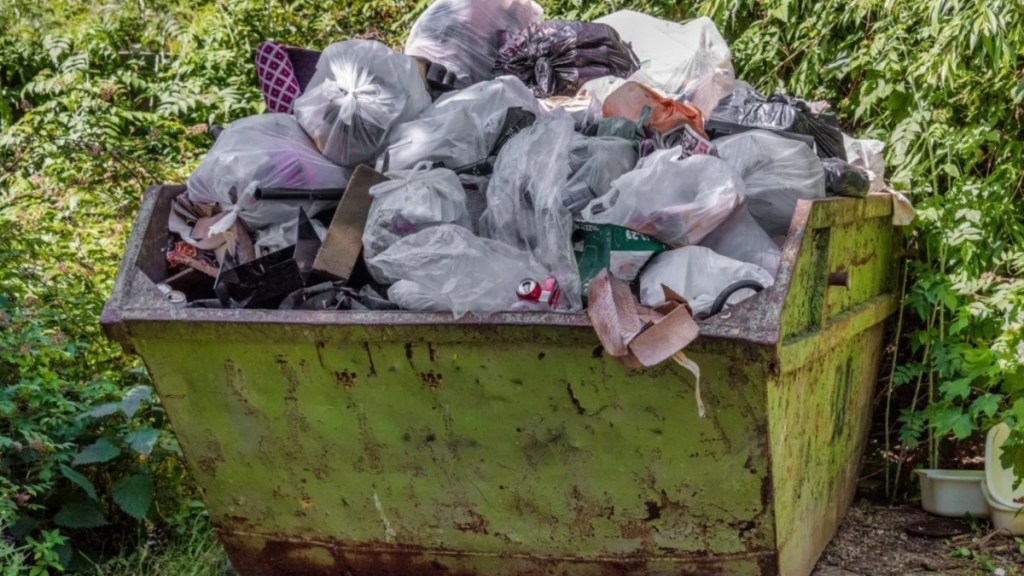 A close up of a yellow skip full of trash, trash collectors in Pennsylvania found dead dogs dumped in trash