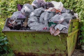 A close up of a yellow skip full of trash, trash collectors in Pennsylvania found dead dogs dumped in trash