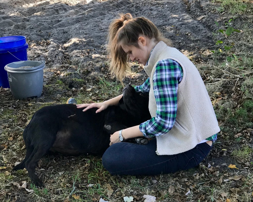 Jenna on the farm with a Black Lab mix named Lucy, the best family dog because every dog deserves to have their day in the sun. 