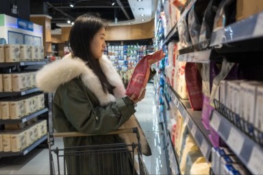 A young woman buying pet food, dog food has become expensive lately.