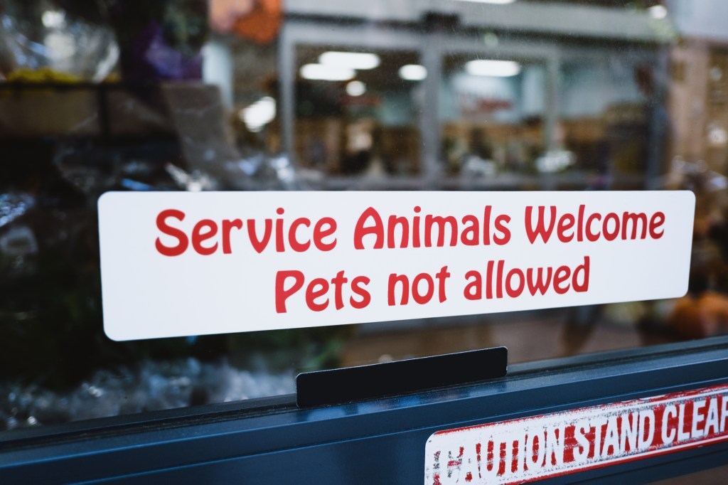 Close-up of sign on grocery store window that welcomes service animals but not pets