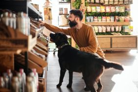 Young man and his dog explore the pet store, similar to Woof Gang Bakery & Grooming, which is set to open new locations in Kentucky very soon.