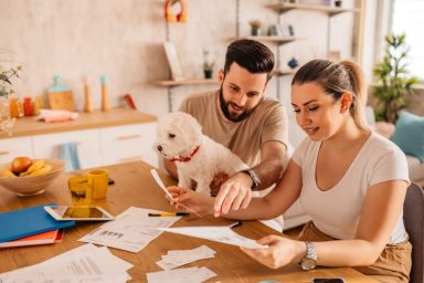 Couple reviewing their finances and the cost of owning a dog at home.