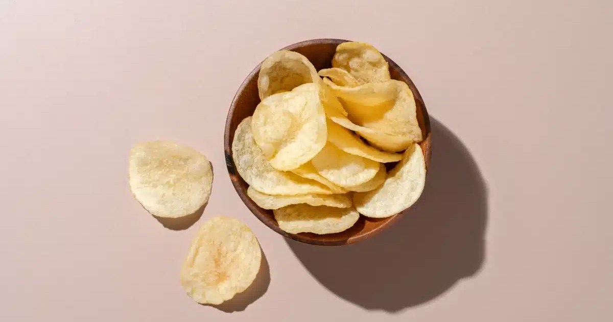 A bowl of potato chips, which dogs should not eat due to their salt, fat, and carb content. Although not toxic, there are safer treats for dogs.