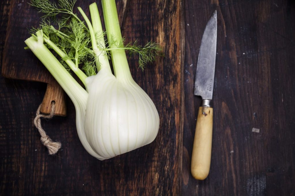 A fennel bulb on a wooden cutting board.
