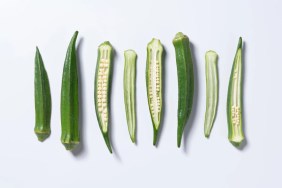 Sliced okra, which is safe for dogs to eat, against a white background.