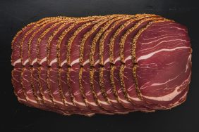 Thinly sliced pastrami meat. with a seasoned outer layer. Dogs cannot eat pastrami due to its high salt and fat content.