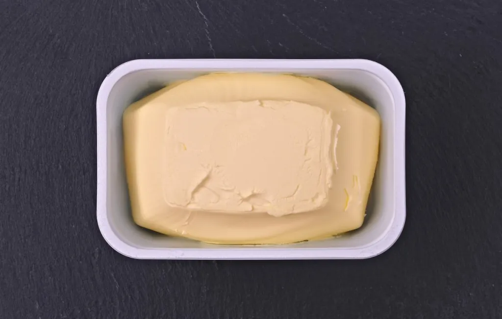 Just opened margarine box on a plate of slate.