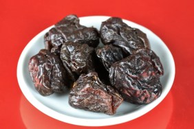 A plate of prunes, which dogs can eat but shouldn't due to their sugar content and pit which contains cyanide.