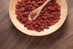 Dried Goji Berries in Wooden Plate on Wooden Background.